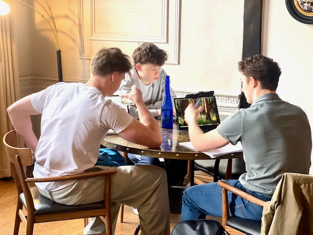 Three students working together around a table